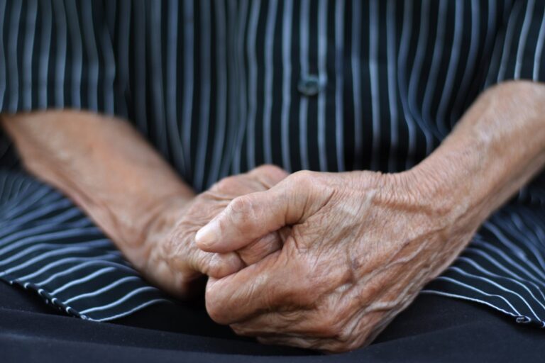 midsection of old woman folding hands