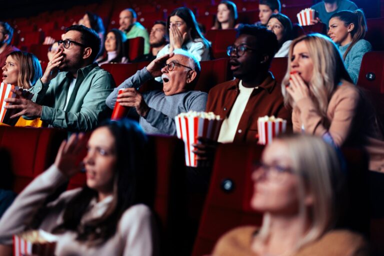 Scared audience in movie theater with popcorn