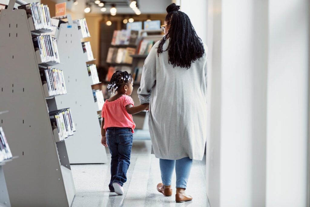 parent and child walking in public library